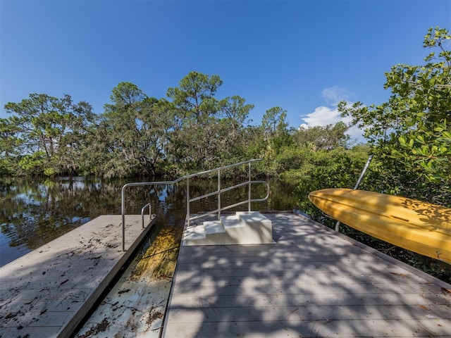 view of patio featuring a water view and a dock