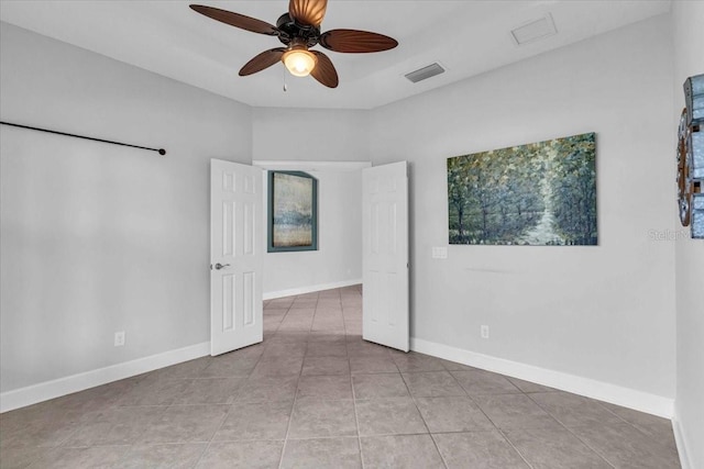 tiled spare room featuring ceiling fan