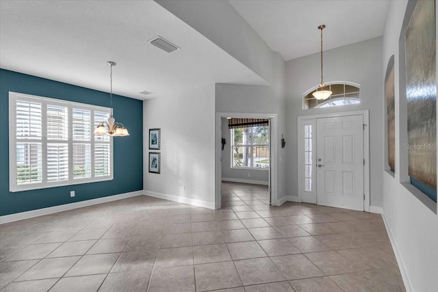 tiled entrance foyer with a chandelier