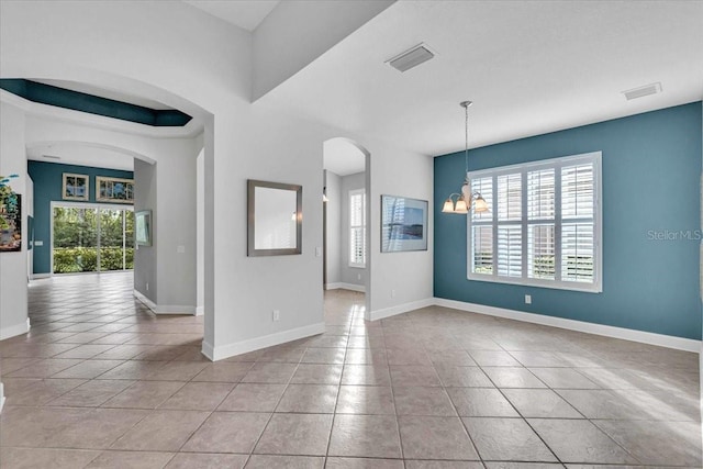 unfurnished room with light tile patterned floors and an inviting chandelier