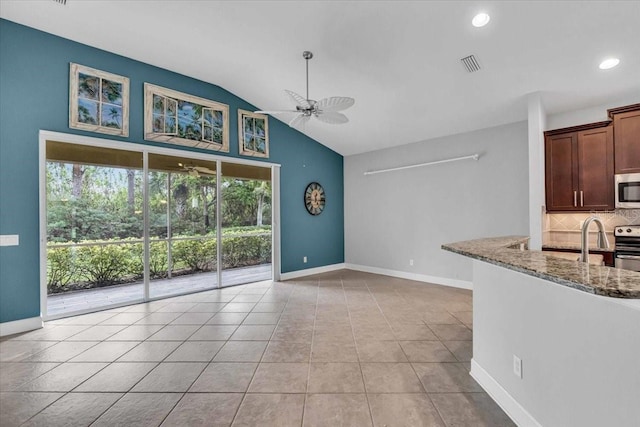 interior space with ceiling fan, decorative backsplash, light tile patterned floors, light stone counters, and stainless steel appliances