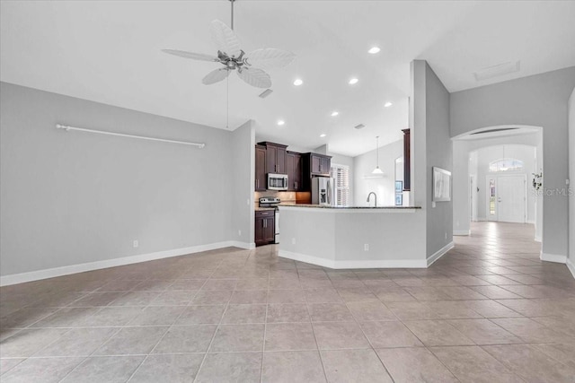 unfurnished living room with ceiling fan, light tile patterned flooring, lofted ceiling, and sink