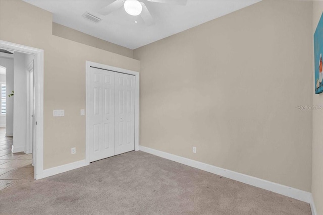 unfurnished bedroom with a closet, ceiling fan, and light colored carpet