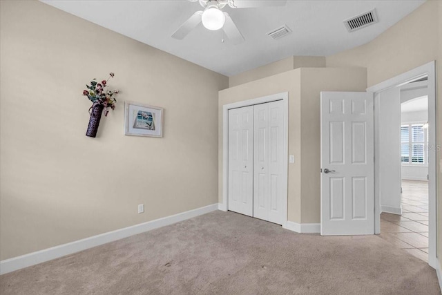 unfurnished bedroom featuring ceiling fan, a closet, and light colored carpet