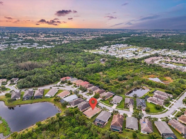 aerial view at dusk featuring a water view