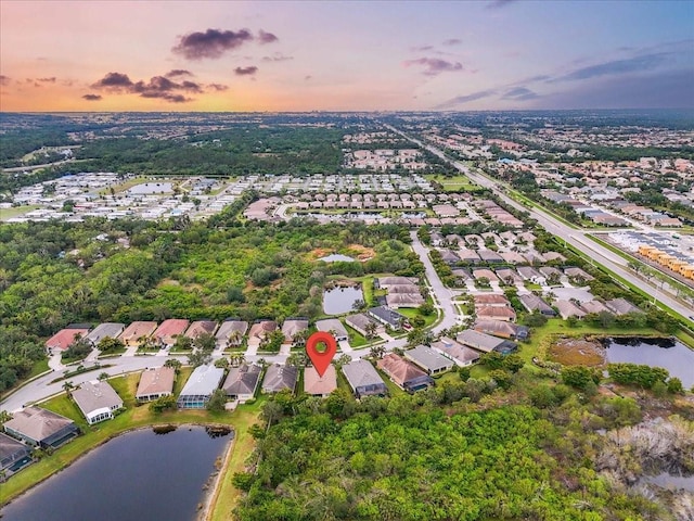 aerial view at dusk featuring a water view