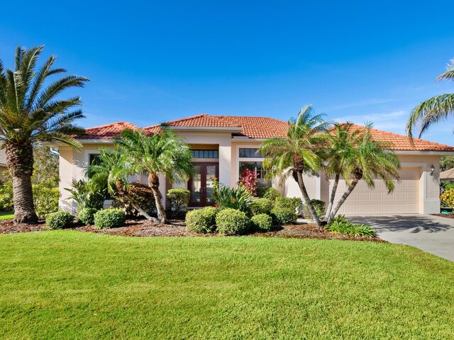 mediterranean / spanish-style house featuring a garage and a front yard