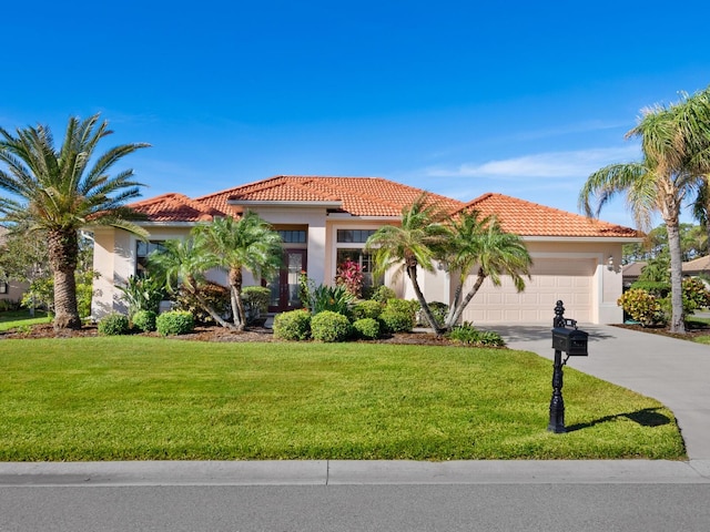 mediterranean / spanish house featuring a garage and a front yard