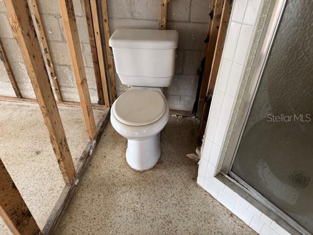 bathroom featuring toilet and an enclosed shower