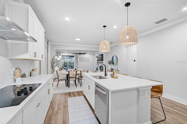 kitchen with a kitchen island with sink, black electric stovetop, stainless steel dishwasher, wall chimney exhaust hood, and white cabinetry