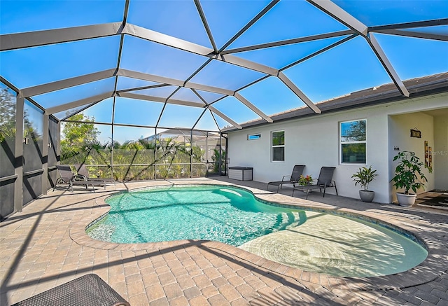 view of swimming pool with a patio area and a lanai