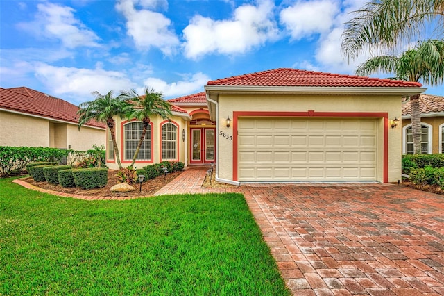 mediterranean / spanish house with a garage, a front yard, and french doors