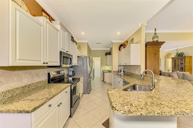 kitchen featuring white cabinetry, sink, kitchen peninsula, crown molding, and appliances with stainless steel finishes