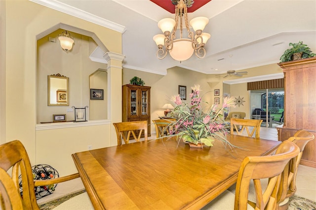 tiled dining area with ceiling fan with notable chandelier, ornate columns, and crown molding