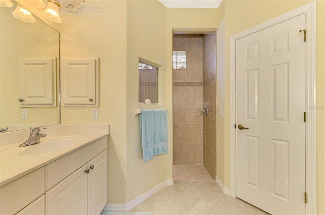 bathroom with tile patterned floors, vanity, a tile shower, and crown molding