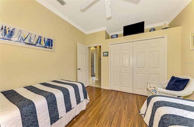 bedroom with ceiling fan, a closet, crown molding, and hardwood / wood-style flooring