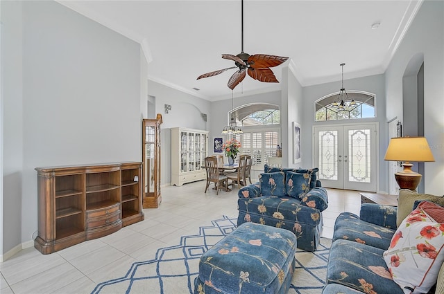 living room with french doors, ornamental molding, ceiling fan, light tile patterned floors, and a high ceiling