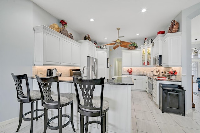 kitchen featuring decorative backsplash, ceiling fan, white cabinets, and stainless steel appliances