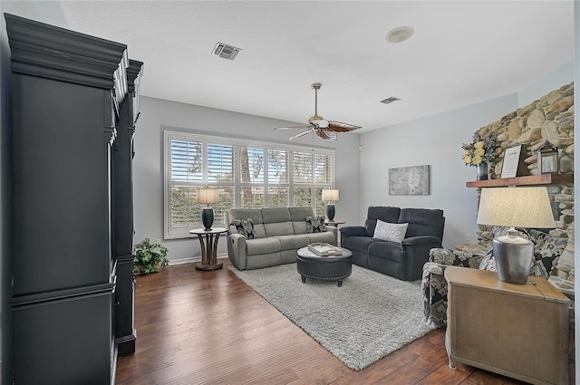 living room featuring ceiling fan and dark wood-type flooring