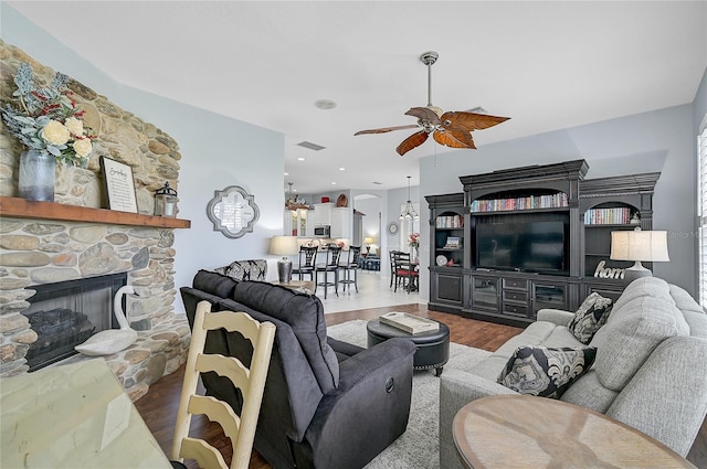 living room featuring hardwood / wood-style floors, ceiling fan, and a fireplace