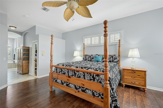 bedroom with hardwood / wood-style floors, ceiling fan, and ensuite bath