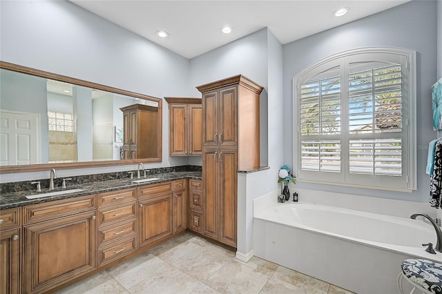 bathroom with tile patterned flooring, a bath, and vanity