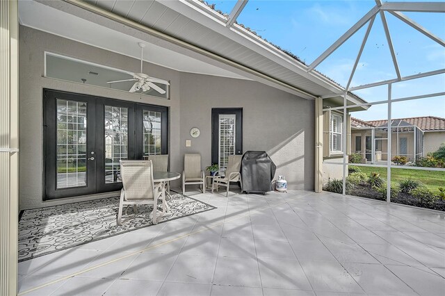 view of patio featuring glass enclosure, ceiling fan, and a grill