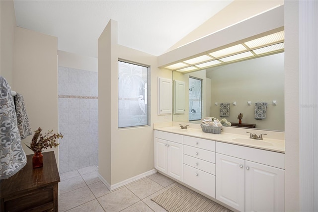 bathroom featuring tile patterned floors, vanity, and vaulted ceiling