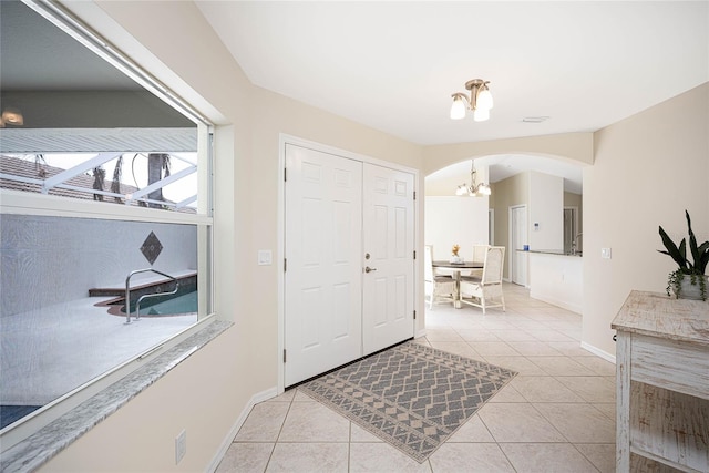 tiled foyer entrance featuring a chandelier