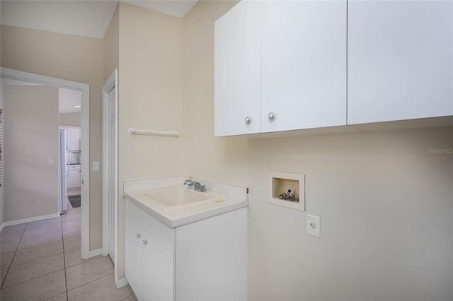 laundry room with cabinets, light tile patterned floors, sink, and hookup for a washing machine