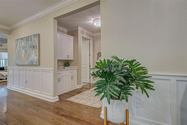 hallway with crown molding and hardwood / wood-style flooring