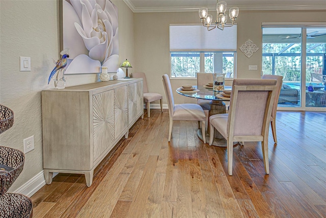 dining space with ornamental molding, a chandelier, and light hardwood / wood-style floors