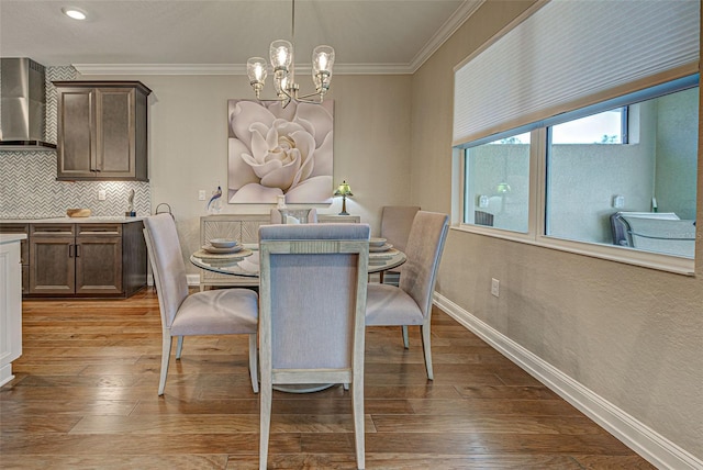 dining space featuring an inviting chandelier, ornamental molding, and light hardwood / wood-style floors