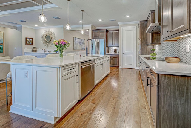 kitchen with white cabinetry, a spacious island, stainless steel appliances, and a kitchen breakfast bar