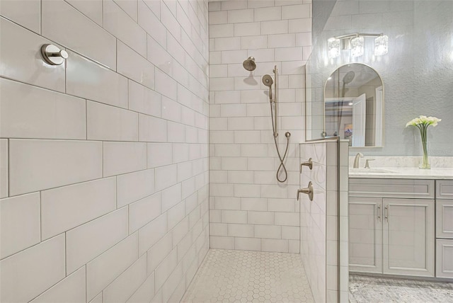 bathroom with vanity and a tile shower