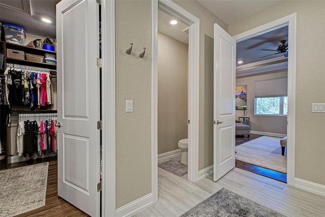 bathroom featuring ceiling fan, hardwood / wood-style flooring, and toilet