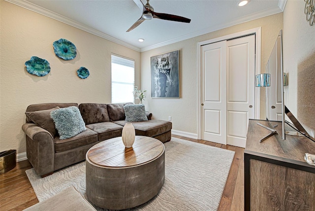 living room with ornamental molding, hardwood / wood-style floors, and ceiling fan