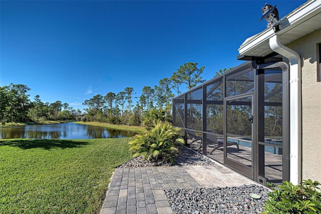 view of yard with a water view, a patio, and glass enclosure