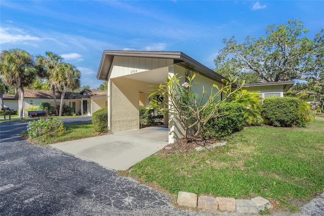 view of front facade with a front lawn and a carport