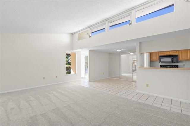 unfurnished living room featuring a textured ceiling, light colored carpet, and high vaulted ceiling