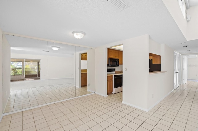 interior space featuring light tile patterned flooring and white electric stove