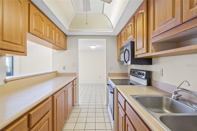 kitchen with stainless steel electric stove, ceiling fan, sink, and light tile patterned floors