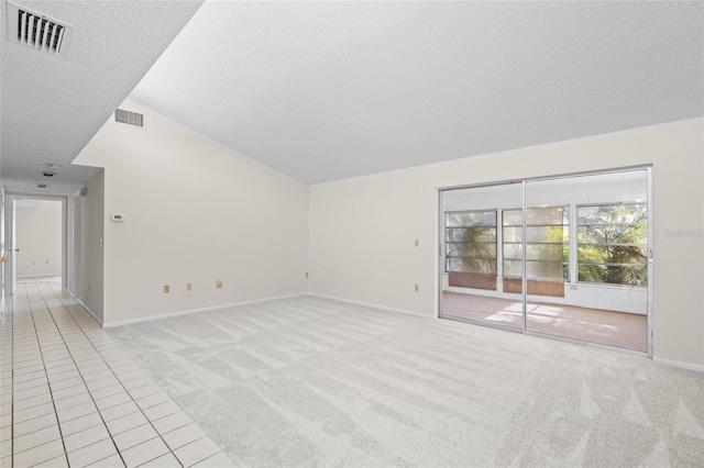 spare room featuring a textured ceiling, light carpet, and high vaulted ceiling