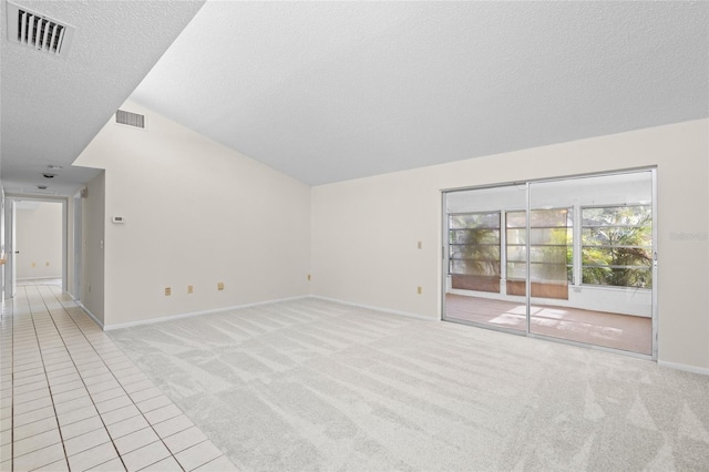 6906 Woodwind Dr Unit 12, Sarasota, FL 34231 - unfurnished living room with a textured ceiling, vaulted ceiling, baseboards, light colored carpet, and light tile patterned flooring