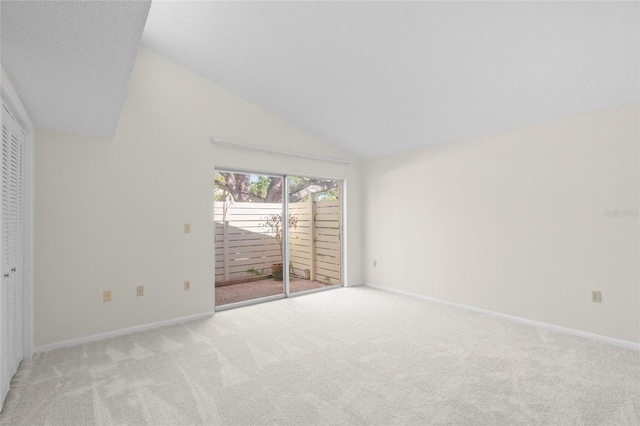 carpeted empty room with high vaulted ceiling