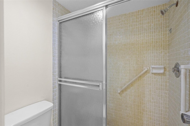 bathroom with toilet and a shower with shower door