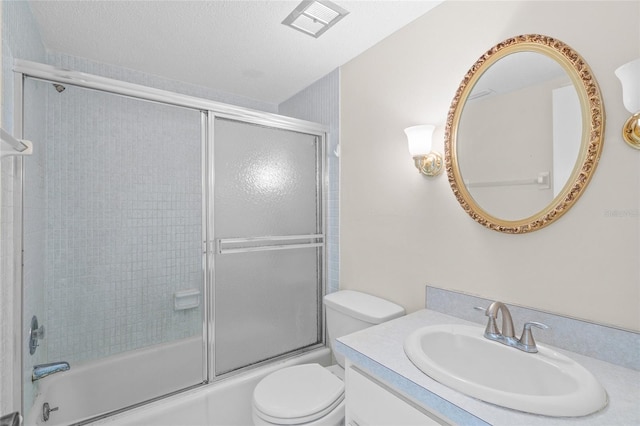 full bathroom featuring shower / bath combination with glass door, vanity, a textured ceiling, and toilet