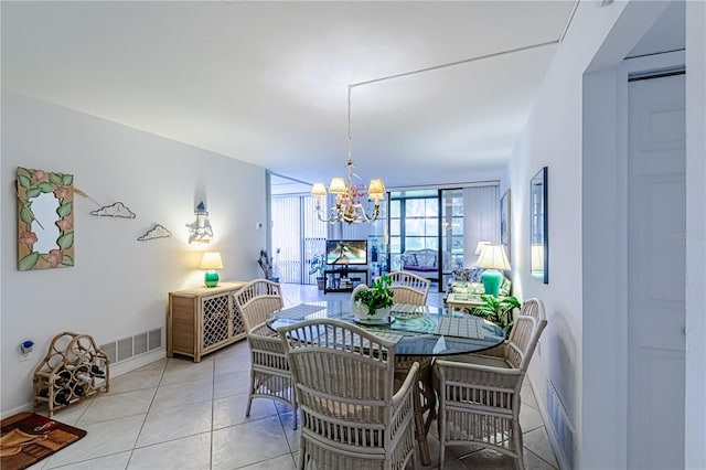 dining space featuring light tile patterned flooring, a chandelier, and a wall of windows