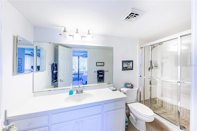 bathroom with tile patterned flooring, vanity, a shower with door, and toilet