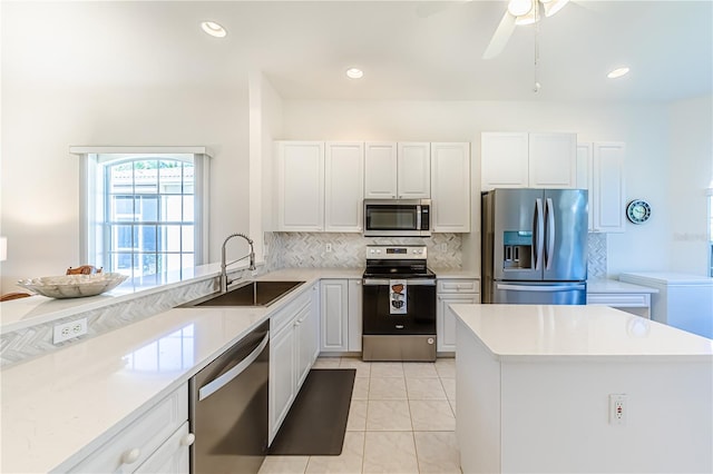 kitchen with ceiling fan, sink, stainless steel appliances, light tile patterned floors, and white cabinets